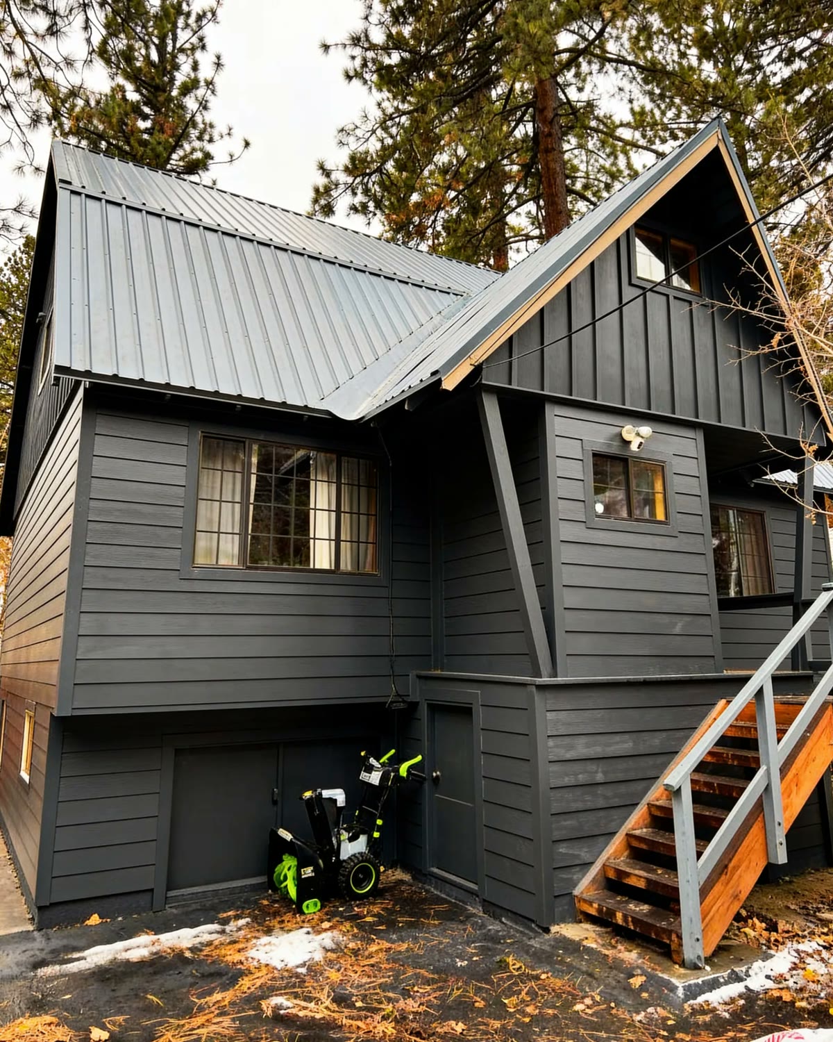 The house after: restored siding repainted deep charcoal